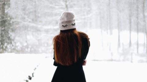 Lonely girl walking on snow.
